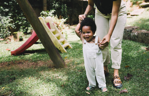 istock Mom teaching her cute little baby to walk 2193544907