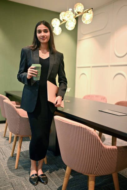 istock Professional woman holding coffee in a modern workspace 2193545500