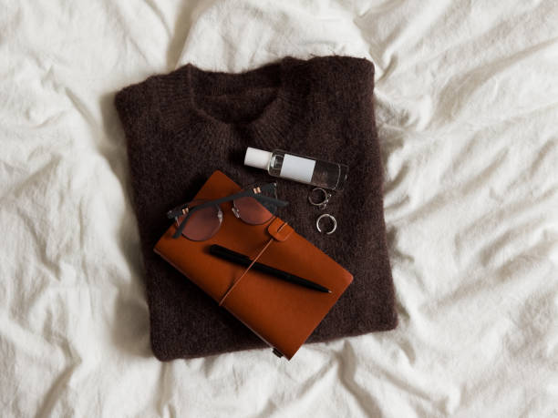 istock Women's cashmere sweater, diary, perfume, jewelry on a light background, top view 2193549377