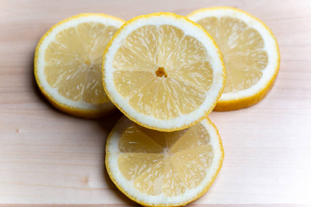 Cut round slice of lemon with knife on isolated on white background. Selective focus with shallow depth of field.