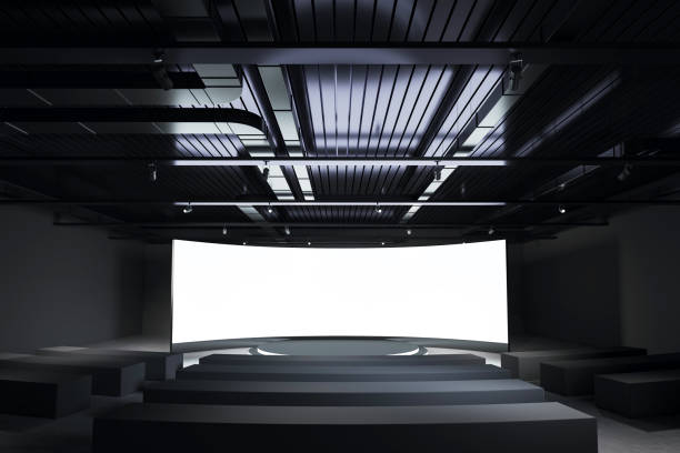 istock Modern conference room with large blank curved screen and dark ceiling design. 3D Rendering 2193553880