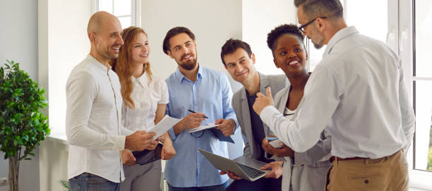 istock Happy multinational business people are talking at event in the office. 2193557147