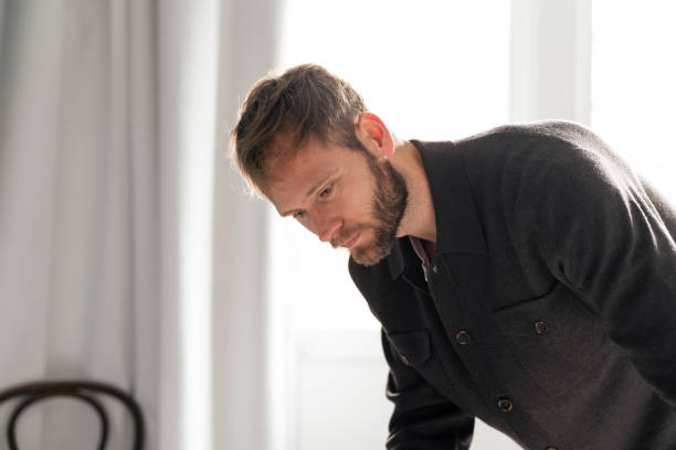istock Thoughtful Young Man Looking Down in a Bright Room 2193560146