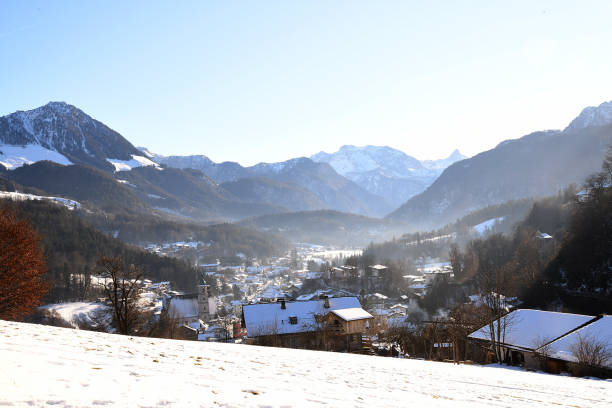 winter landscape with a picturesque valley surrounded by snowy mountains. Cozy houses located on a slope