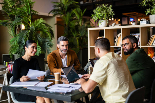 istock Four multiracial business colleagues in meeting with laptops and paperwork 2193568092