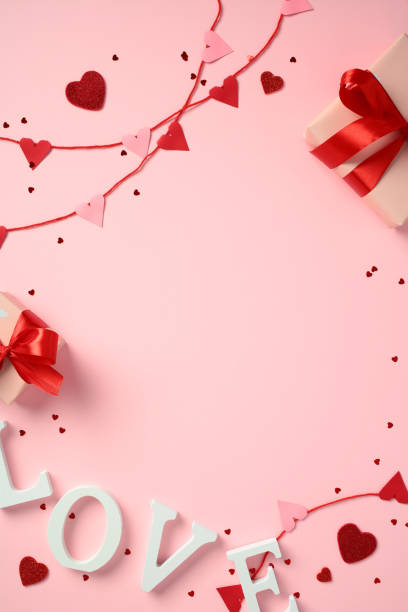 istock Valentine's Day composition. Top view red and pink heart garland, gift boxes with red ribbons, and the word 'LOVE' spelled out in white letters. Perfect for romantic and festive content 2193568741