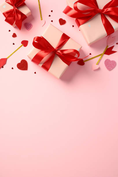 istock Valentine's Day vertical background for social media stories. Top view pink gift boxes wrapped in red ribbons, surrounded by glittery hearts and Cupid's arrows on a pink background. Perfect for romant 2193569162