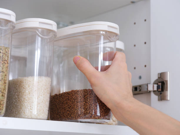 istock A man taking a plastic container of buckwheat out of a kitchen cabinet. 2193571752