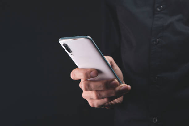 istock man hand holding a black smartphone. 2193572244