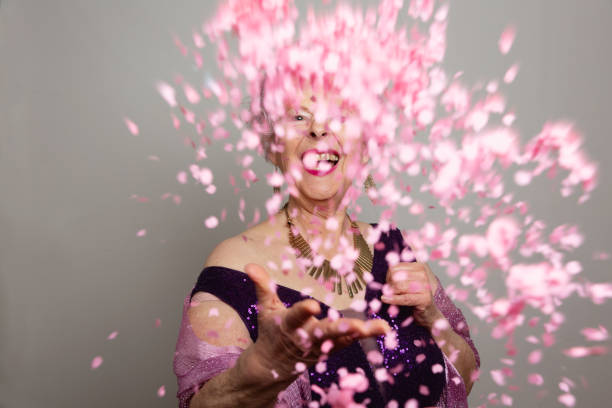 istock senior woman dressed for a party celebrating with confetti 2193573636