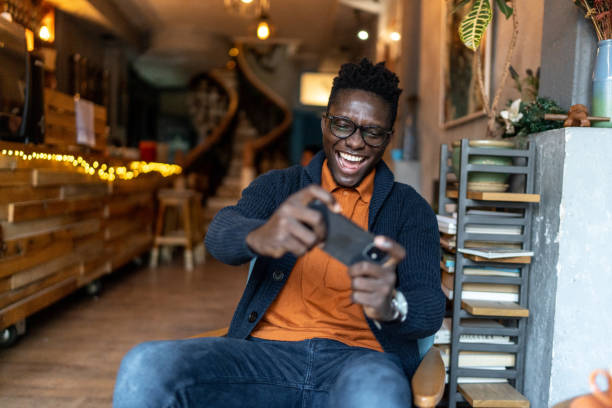 istock Young man playing video games on smartphone at coffee 2193575947