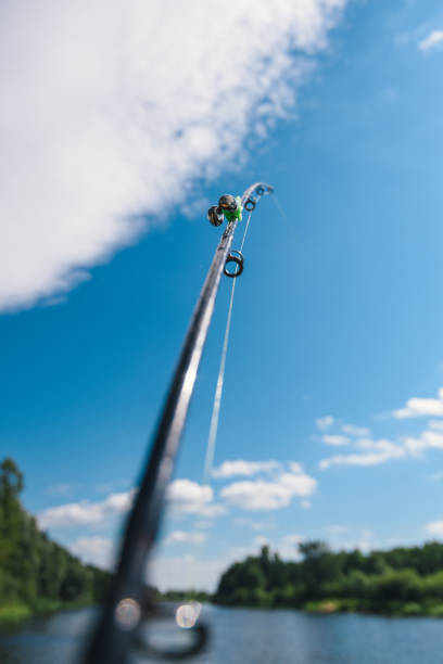 istock Fishing rod with line against blue sky 2193576737