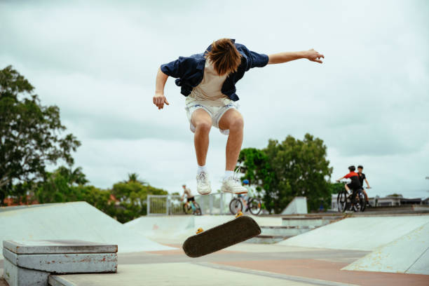 istock Gen-Z skateboarder practicing tricks on a half-pipe in an outdoor skate park on a cloudy day 2193578877