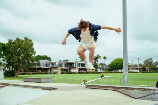 istock Young skateboarder practicing tricks on a half-pipe in an outdoor skate park on a cloudy day 2193578890