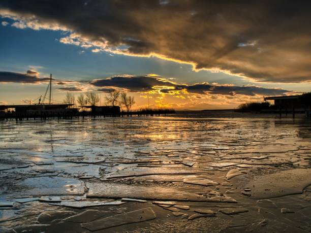 istock Frozen lake sunset with silhouetted trees. 2193579364