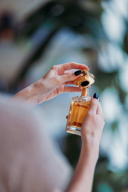 istock Hands Holding Perfume Bottle with Elegant Golden Cap Close-Up 2193580213
