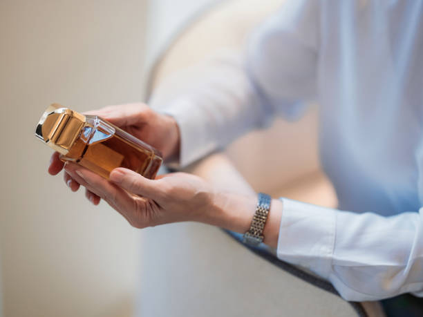 istock Close-Up of Hands Holding a Luxurious Perfume Bottle in Elegant Setting 2193580224