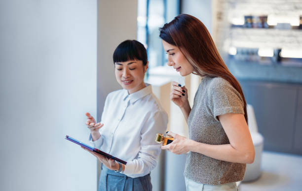 Two Women Discussing Perfume Options in a Modern Retail Setting