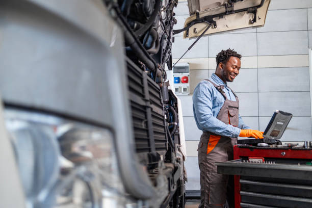 istock Truck mechanic using laptop diagnostic tool and servicing vehicle. 2193580346