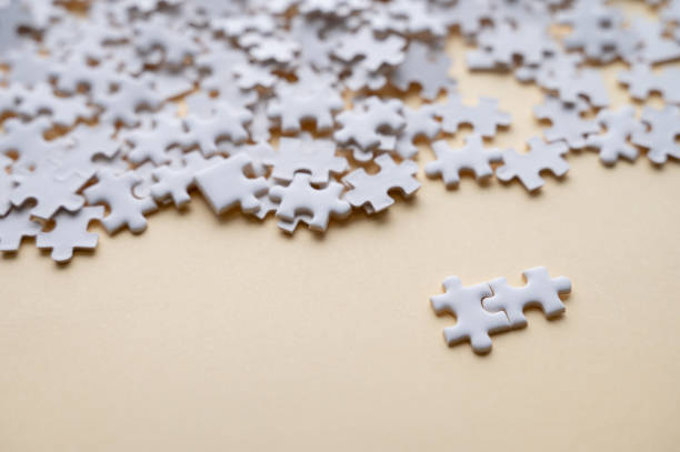 istock Scattered White Puzzle Pieces on Beige Background 2193580367