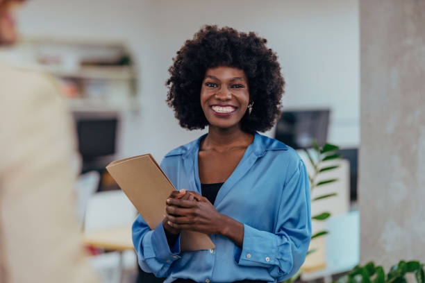 istock Confident Businesswoman Holding a Folder Smiling in a Bright Office Setting 2193581126