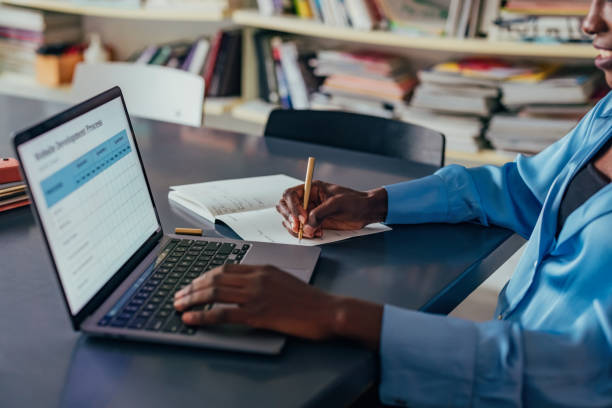 istock Professional Individual Working on a Laptop and Taking Notes at a Desk 2193581128