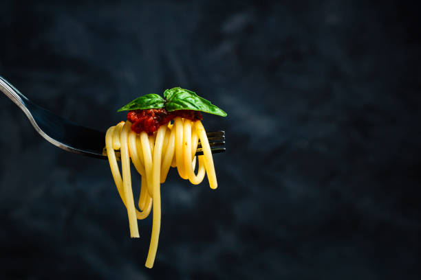 istock Italian spaghetti on fork on dark background. Close up. 2193582090