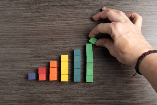 istock Hand of a man making an ascending bar chart with wooden blocks. 2193586192