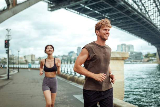 istock Young multiracial couple running together outdoors in Sydney 2193588346