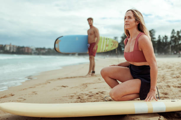 istock Couple on a beach with surf boards 2193589605