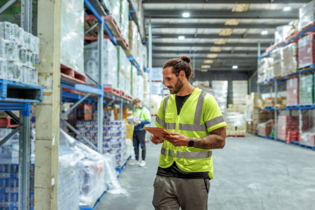istock Warehouse worker in reflective clothing using digital tablet at storage room 2193589728