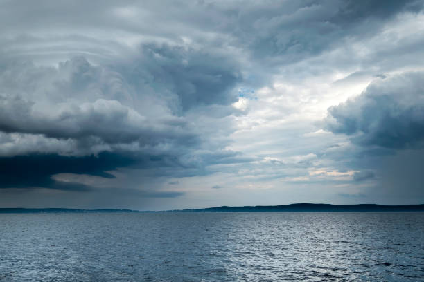 Cloudy rainy weather. Beautiful dark dramatic sky and lake.