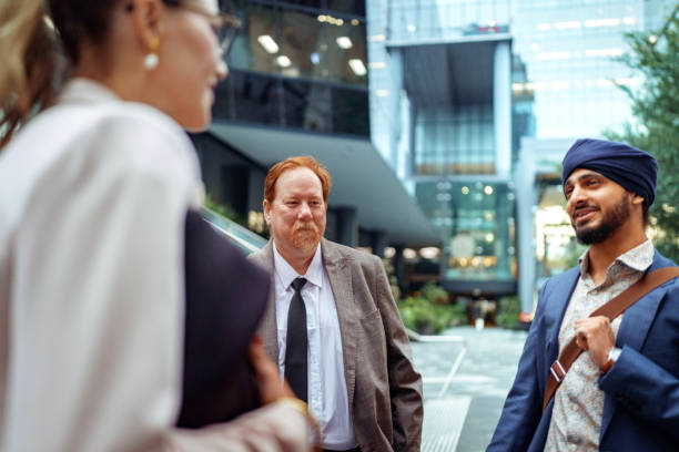 istock Three well dressed business colleagues talking outdoors at the city 2193590926