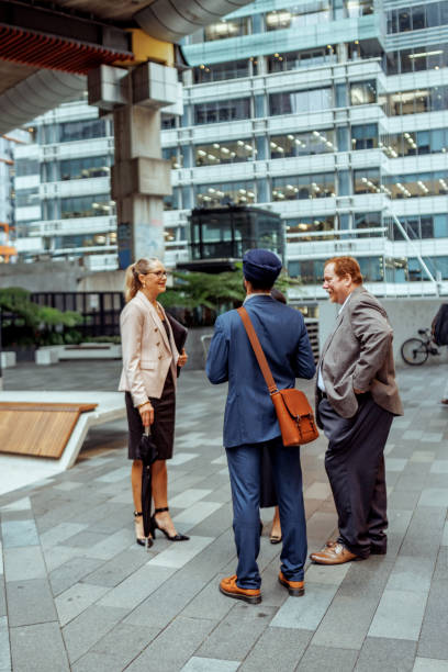 istock Three well dressed business colleagues talking outdoors at the city 2193590936
