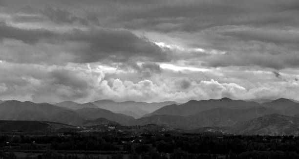 A stunning view of layered mountains in dramatic clouds at twilight, highlighting nature's beauty.