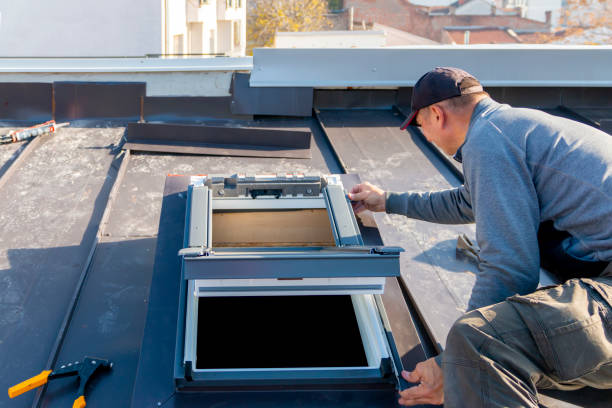 A roofer and window master work. The craftsman covers the skylight with sheet metal. Roofing tools.