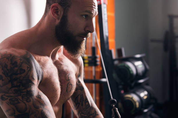 concentrated muscular man doing exercise at gym