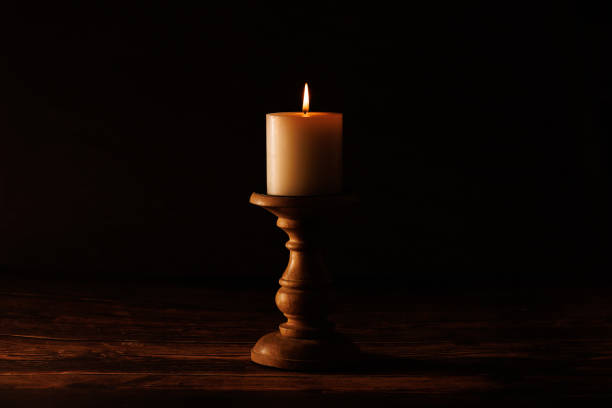 istock Lit candle on a wooden holder 2193598686