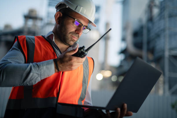 istock Engineer working with laptop and report a problem on walkie talkie in the evening. 2193599026