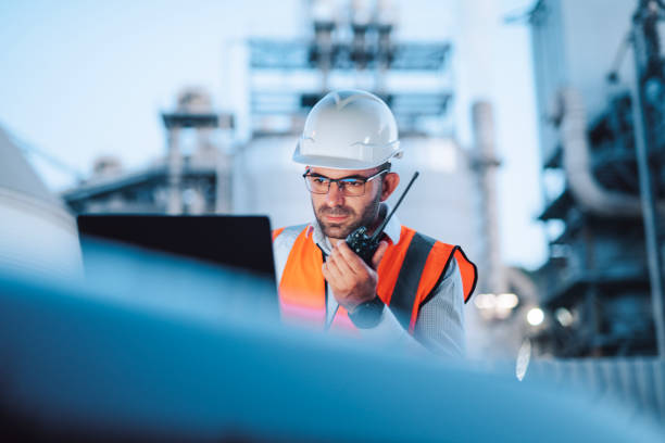 Engineer is reptorting a problem with a walkie talkie on the power station at a night shift.