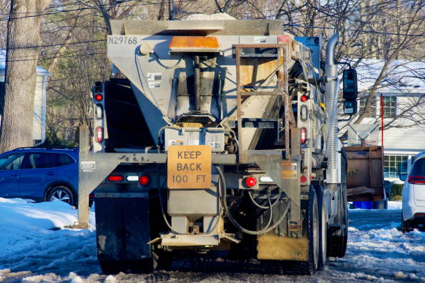Fairfax, Virginia, USA - January 11, 2025: A Virginia Department of Transportation (VDOT) snowplow works to remove slush and ice from a neighborhood road in suburban Northern Virginia following Winter Storm Blair.