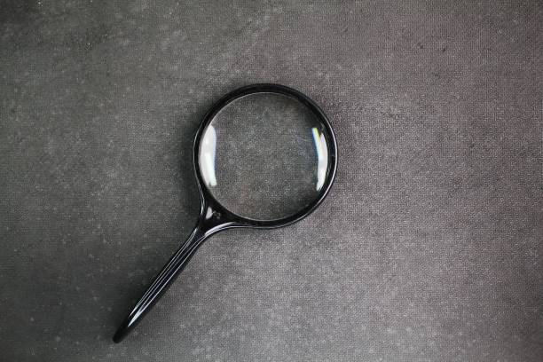 istock Plastic black magnifying glass isolated on dark gray or black background,top view. the concept of research or search. 2193602201