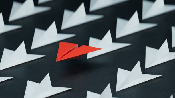 istock Different business concept.new ideas. paper art style. creative idea. red leader plane, standing out from the crowd of white planes.3D rendering on black background. 2193607019