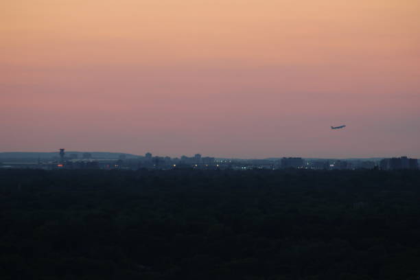 View from afar of plane taking off at Toronto Pearson airport around sunset