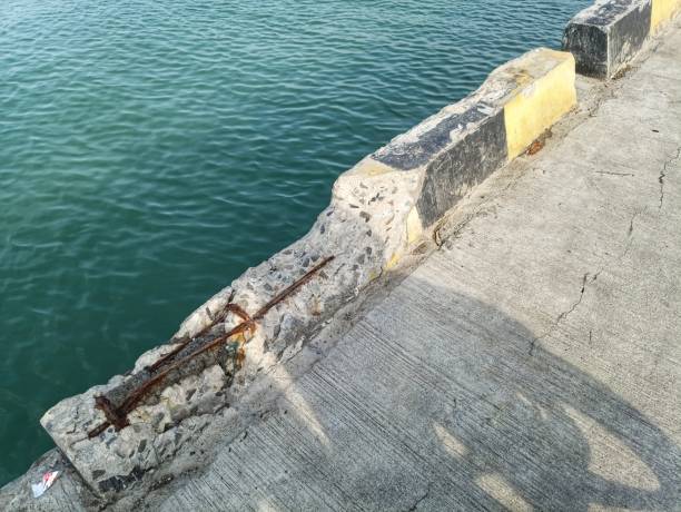 istock yellow and black concrete barrier damaged. 2193611901