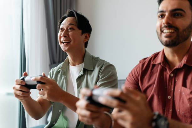 istock Two multiracial Asian man playing video game together at home 2193622069