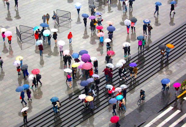 China, Shanghai, crowd walking in rain on The Bund walkway.
