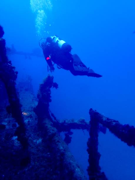 istock Scuba Diver Exploring a Sunken Shipwreck in Deep Blue Ocean 2193627730