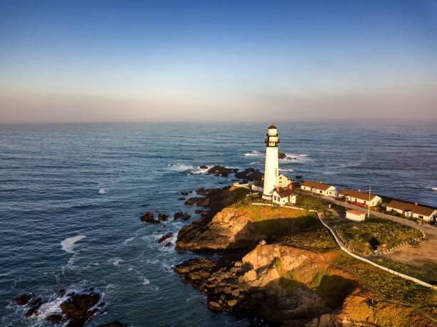 istock Scenic lighthouse on rocky coastline at sunset 2193631567