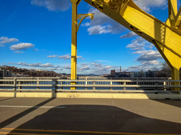 istock Yellow bridge and a blue sky with fluffy clouds over a river scene 2193632429